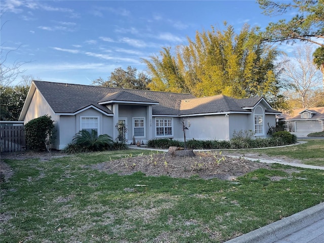 ranch-style home featuring a front lawn and stucco siding