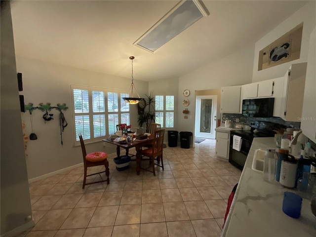 dining space with lofted ceiling, light tile patterned flooring, and baseboards