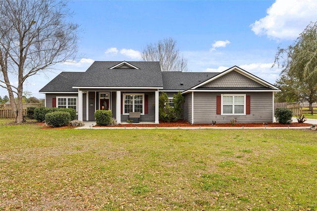 view of front of house with a front lawn, fence, and roof with shingles