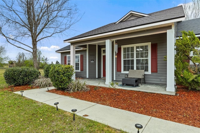 view of front of house with a porch and a shingled roof