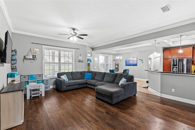 living area featuring visible vents, crown molding, dark wood-type flooring, and baseboards