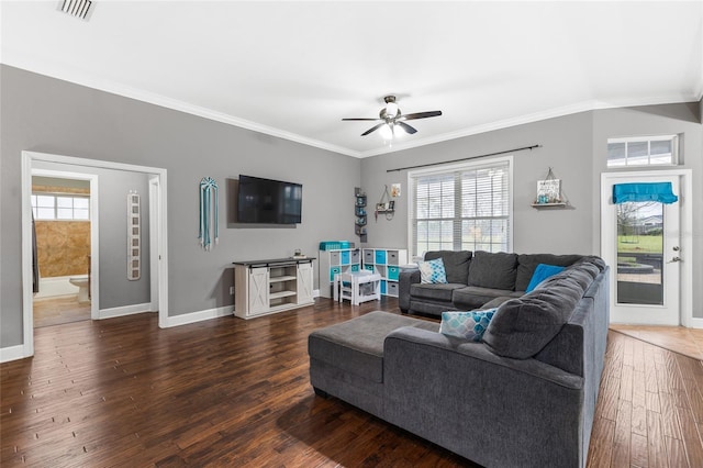 living room with visible vents, baseboards, wood finished floors, and crown molding