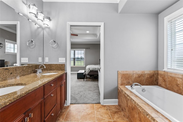 ensuite bathroom featuring tile patterned floors, a bath, double vanity, and a sink