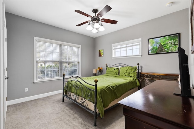 carpeted bedroom featuring multiple windows, baseboards, and ceiling fan