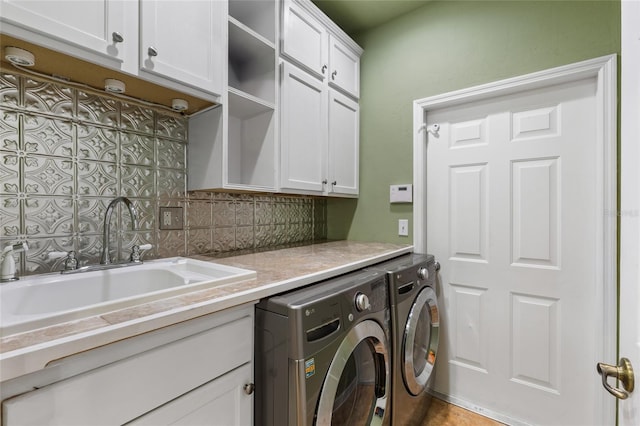 laundry room with washer and clothes dryer, cabinet space, and a sink