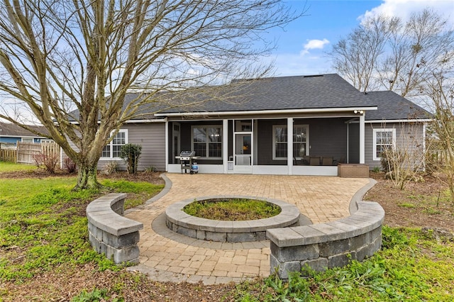 rear view of house featuring a patio area, a shingled roof, fence, and a sunroom