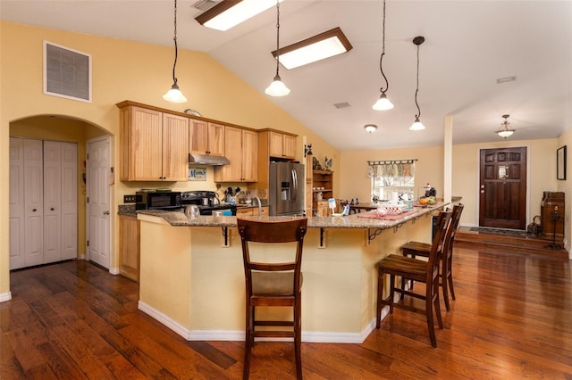 kitchen featuring visible vents, light brown cabinetry, black gas range, stainless steel refrigerator with ice dispenser, and under cabinet range hood