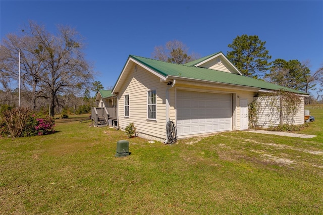 view of property exterior with a garage, metal roof, and a yard