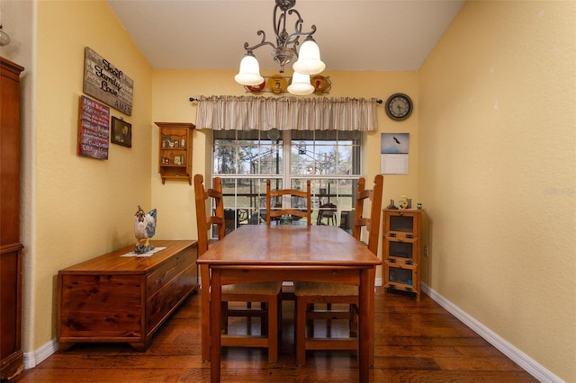 dining room featuring baseboards, wood finished floors, and a chandelier