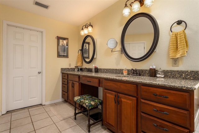 bathroom featuring tile patterned floors, visible vents, double vanity, and a sink