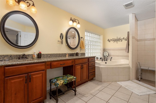 bathroom featuring tile patterned flooring, visible vents, double vanity, a bath, and a textured ceiling