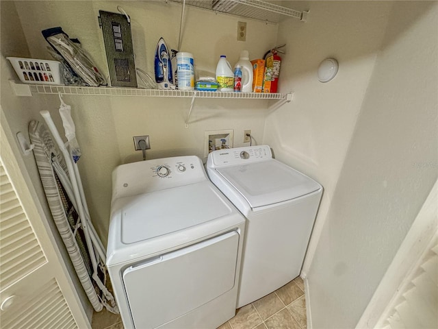 laundry area with laundry area, light tile patterned flooring, and washing machine and clothes dryer