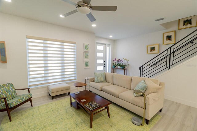 living room featuring visible vents, baseboards, stairway, recessed lighting, and wood finished floors