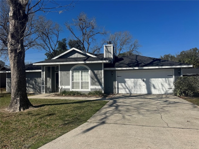 ranch-style home featuring a garage, a chimney, a front lawn, and concrete driveway