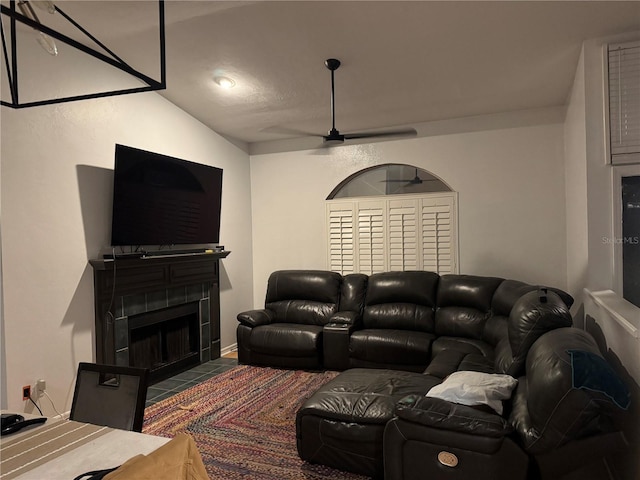 cinema room with a fireplace with flush hearth and ceiling fan