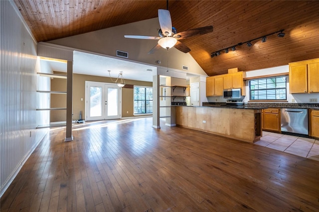 kitchen featuring stainless steel appliances, dark countertops, visible vents, and hardwood / wood-style flooring