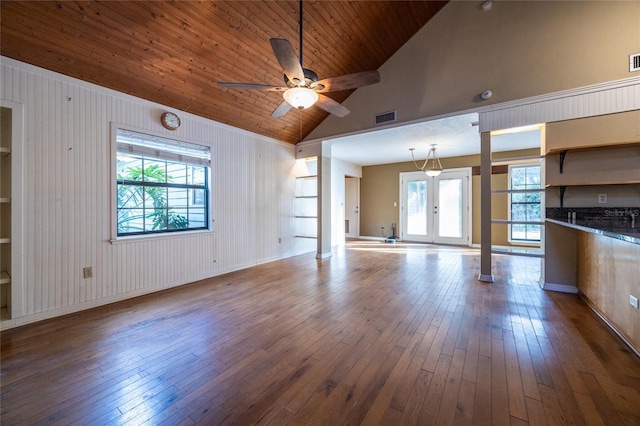 unfurnished living room with a wealth of natural light, dark wood-style flooring, and visible vents