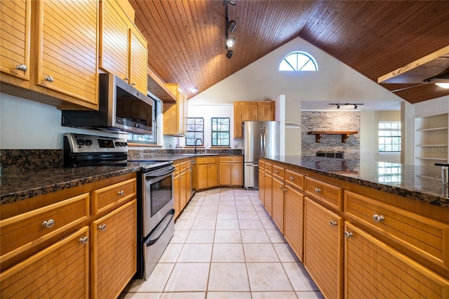 kitchen with appliances with stainless steel finishes, dark stone counters, wooden ceiling, and light tile patterned flooring