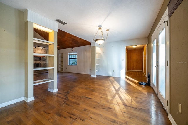 interior space featuring hardwood / wood-style flooring, a fireplace, visible vents, built in features, and baseboards