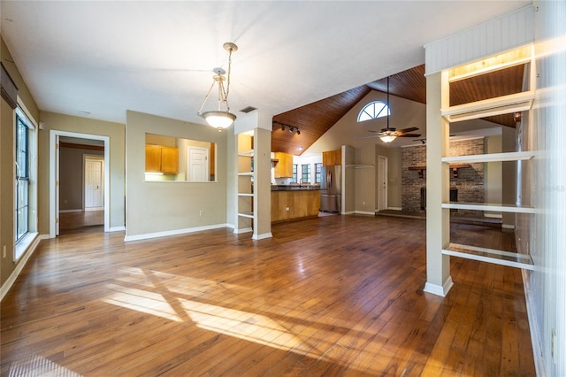 unfurnished living room with ceiling fan, high vaulted ceiling, dark wood-style flooring, a fireplace, and baseboards