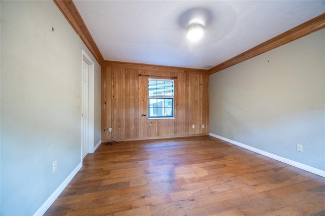 spare room featuring wood finished floors, visible vents, and baseboards