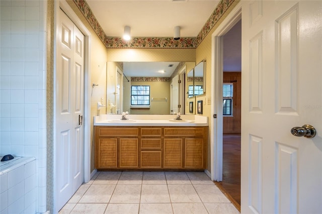 full bathroom with double vanity, a sink, wallpapered walls, and tile patterned floors