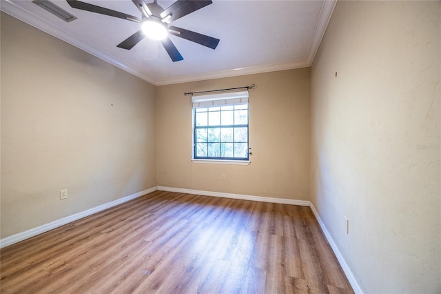 unfurnished room with baseboards, crown molding, visible vents, and wood finished floors