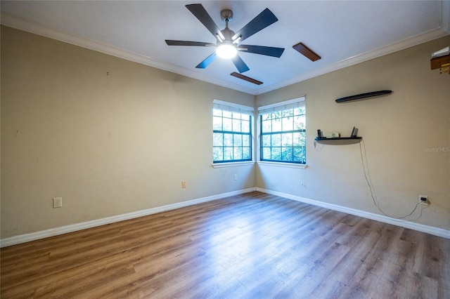 spare room with ornamental molding, a ceiling fan, baseboards, and wood finished floors