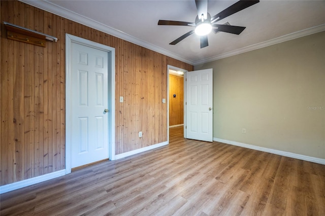 spare room featuring baseboards, ornamental molding, ceiling fan, and wood finished floors