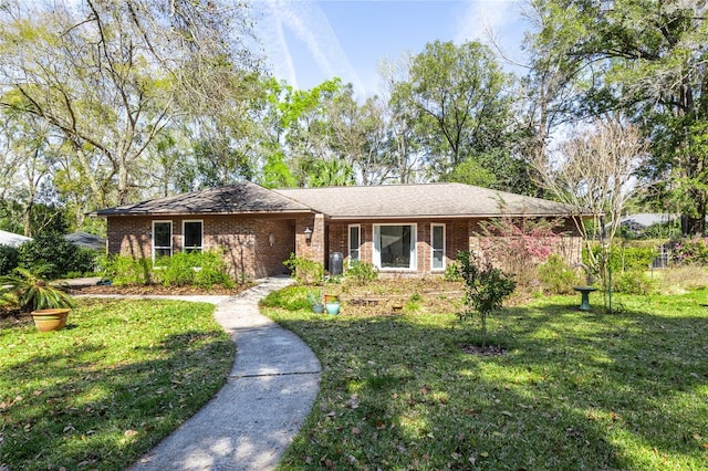 ranch-style home featuring a front lawn and brick siding