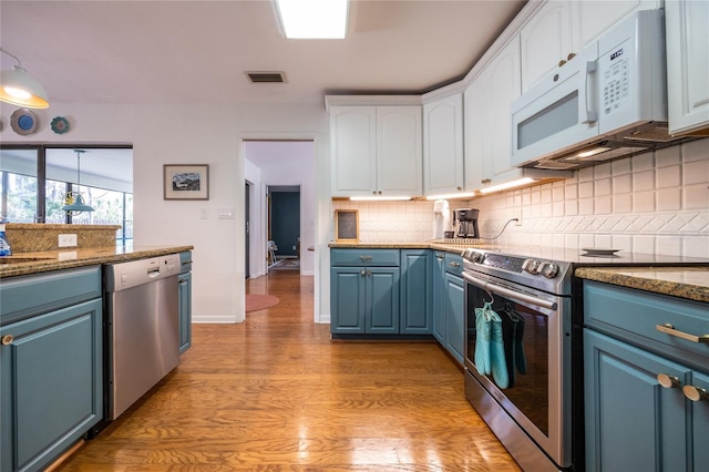 kitchen featuring visible vents, decorative backsplash, appliances with stainless steel finishes, white cabinets, and blue cabinets