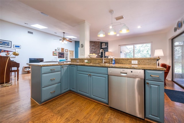 kitchen with blue cabinets, visible vents, a sink, stainless steel dishwasher, and wood finished floors