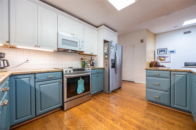 kitchen featuring visible vents, stainless steel appliances, white cabinetry, blue cabinets, and light wood-type flooring