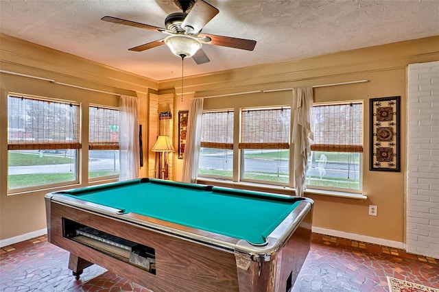 playroom featuring a textured ceiling, baseboards, and a wealth of natural light