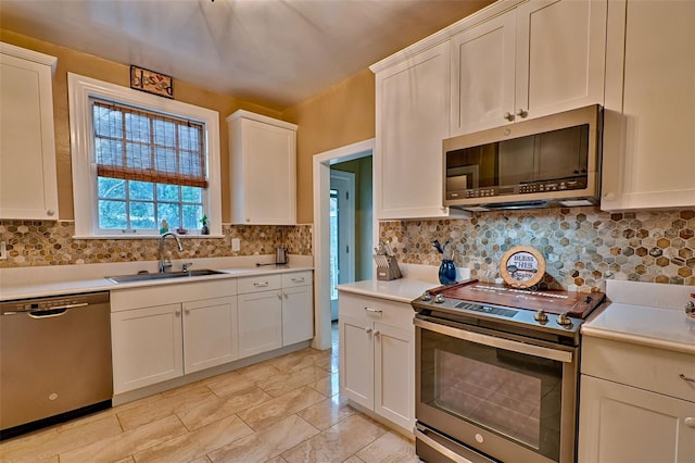 kitchen featuring stainless steel appliances, a sink, light countertops, and white cabinets