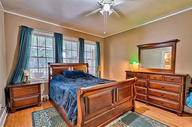 bedroom with a ceiling fan, crown molding, and light wood-style flooring