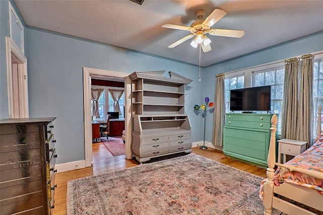 bedroom featuring baseboards, ceiling fan, and light wood-style floors