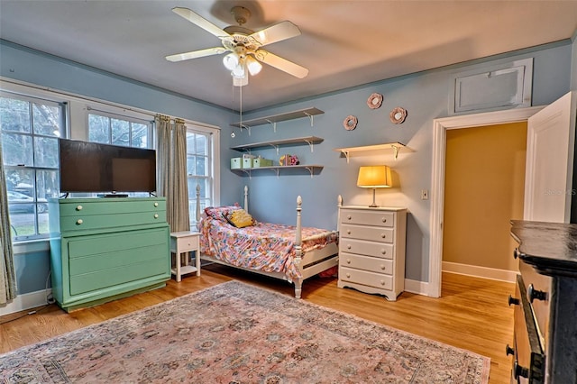 bedroom with ceiling fan, baseboards, and wood finished floors