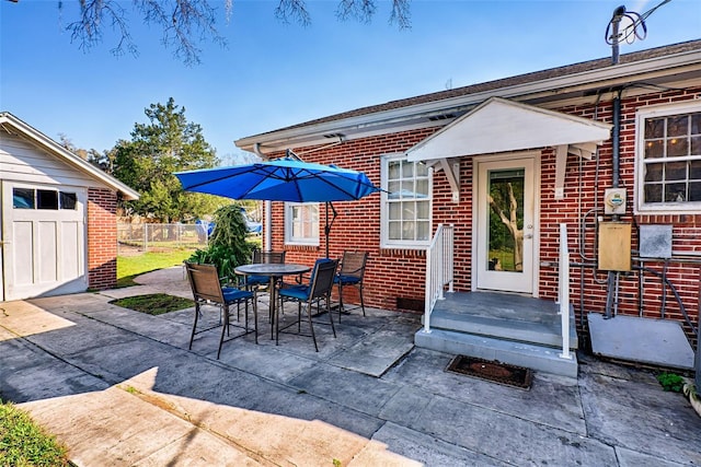 view of patio featuring fence, an outdoor structure, and outdoor dining space