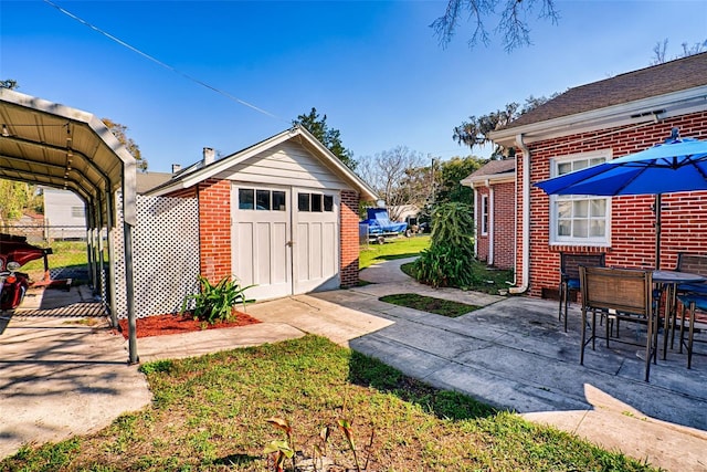 exterior space with outdoor dining area, a patio, a storage unit, a carport, and an outdoor structure