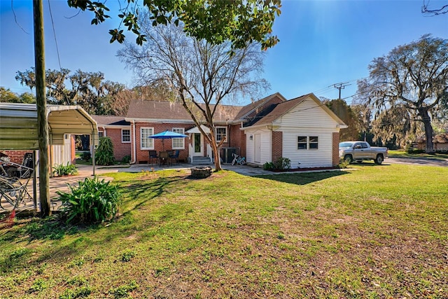 back of property featuring entry steps, a yard, an outdoor structure, and brick siding