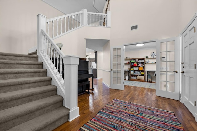 foyer with stairway, dark wood-style floors, french doors, and visible vents