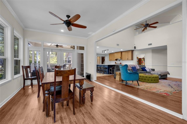 dining space with visible vents, crown molding, baseboards, light wood-style flooring, and french doors