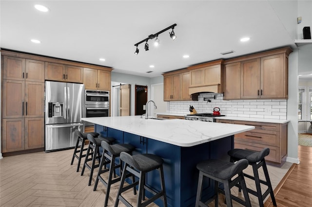 kitchen featuring a sink, decorative backsplash, a kitchen breakfast bar, and appliances with stainless steel finishes