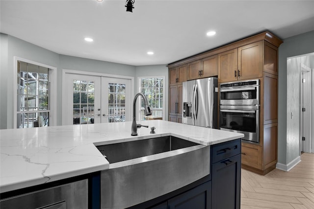 kitchen featuring light stone counters, recessed lighting, french doors, and stainless steel appliances