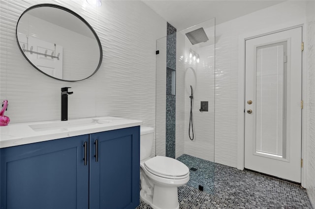 full bathroom with vanity, tile walls, toilet, and a walk in shower