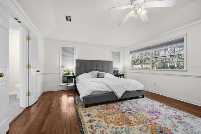 bedroom with visible vents, ceiling fan, baseboards, and wood finished floors