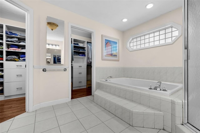 full bathroom with a spacious closet, tile patterned flooring, recessed lighting, and a bath