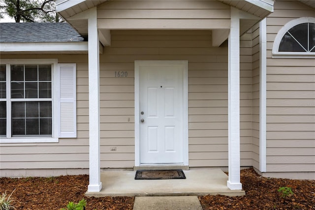 property entrance with a shingled roof