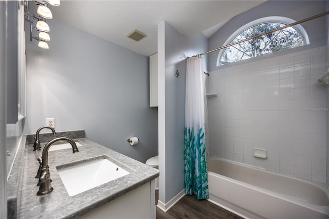 full bathroom featuring wood finished floors, a sink, visible vents, shower / tub combo with curtain, and double vanity